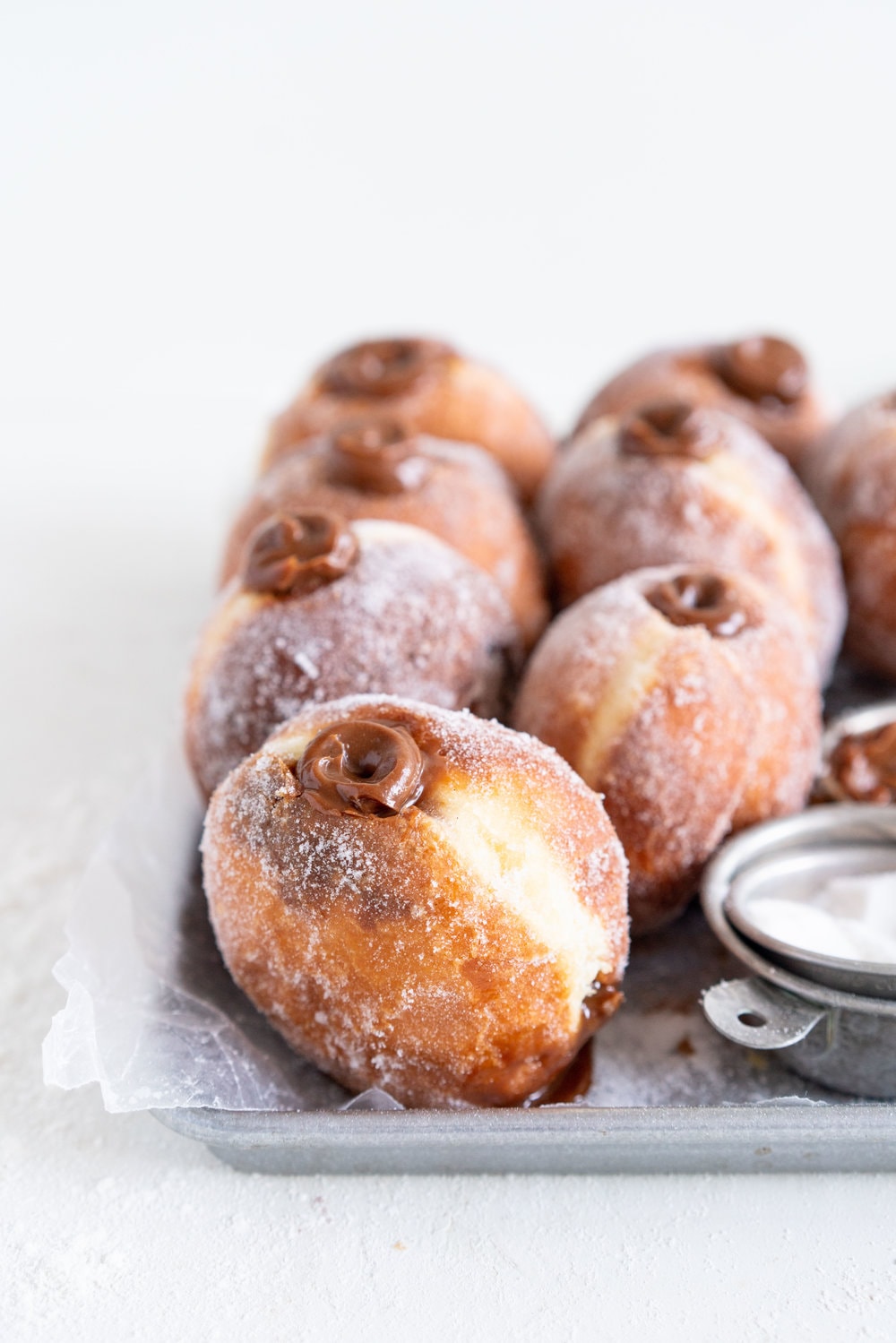 Salted Caramel and Milk Chocolate Ganache filled Brioche Doughnuts - Fluffy brioche doughnuts are rolled in sugar, then filled with a silky salted caramel and milk chocolate ganache. These are the ultimate treat - the rich chocolate ganache is a total game changer. #doughnuts #briochedoughnuts
