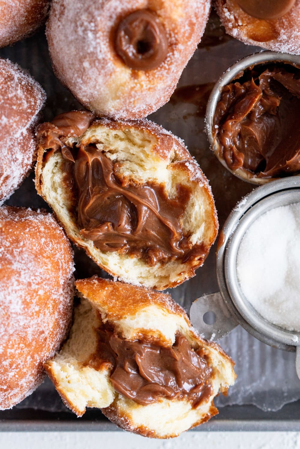 Salted Caramel and Milk Chocolate Ganache filled Brioche Doughnuts - Fluffy brioche doughnuts are rolled in sugar, then filled with a silky salted caramel and milk chocolate ganache. These are the ultimate treat - the rich chocolate ganache is a total game changer. #doughnuts #briochedoughnuts