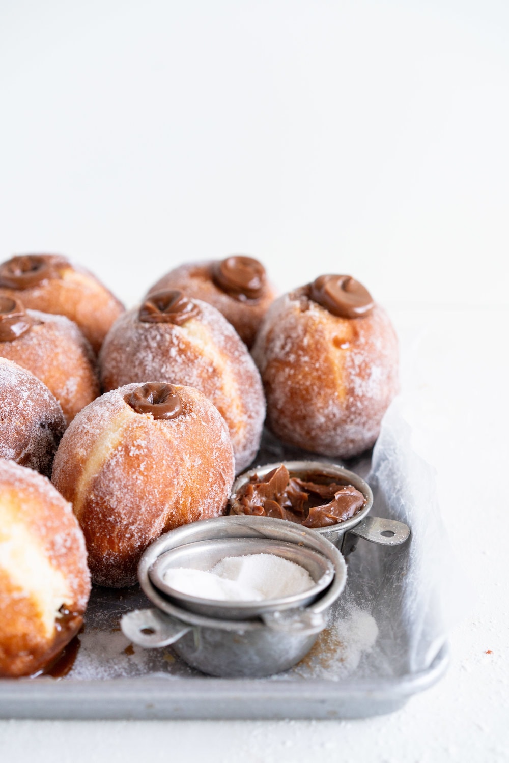 Salted Caramel and Milk Chocolate Ganache filled Brioche Doughnuts - Fluffy brioche doughnuts are rolled in sugar, then filled with a silky salted caramel and milk chocolate ganache. These are the ultimate treat - the rich chocolate ganache is a total game changer. #doughnuts #briochedoughnuts