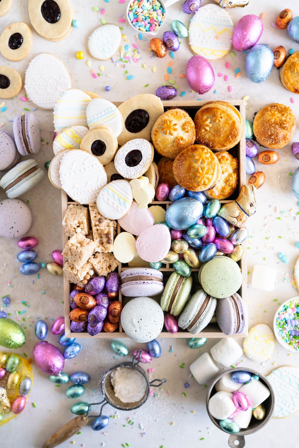 The Ultimate Easter treat box - iced cookies, cardamom linzers, hand pies, macarons, crispy rice treats and Easter mallows make the most amazing treat box, and are complimented perfectly by super cute foil wrapped chocolate eggs. This box would make the most perfect Easter gift, or the components are perfect alone for Easter treats. #easterbox #cookiebox #easterbaking