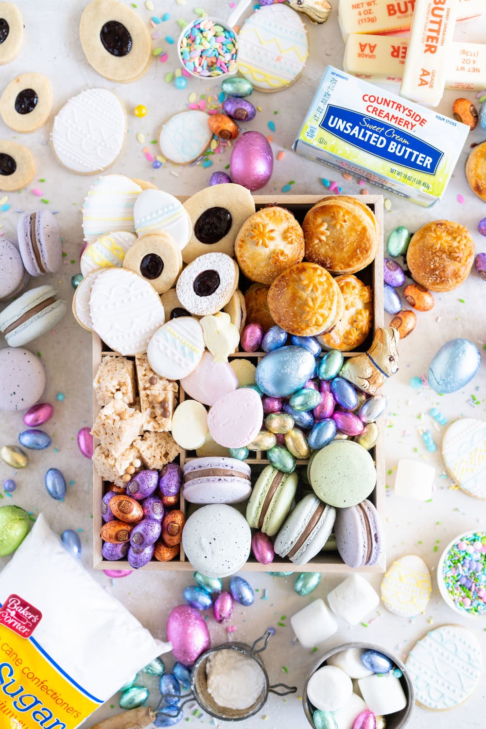 The Ultimate Easter treat box - iced cookies, cardamom linzers, hand pies, macarons, crispy rice treats and Easter mallows make the most amazing treat box, and are complimented perfectly by super cute foil wrapped chocolate eggs. This box would make the most perfect Easter gift, or the components are perfect alone for Easter treats. #easterbox #cookiebox #easterbaking