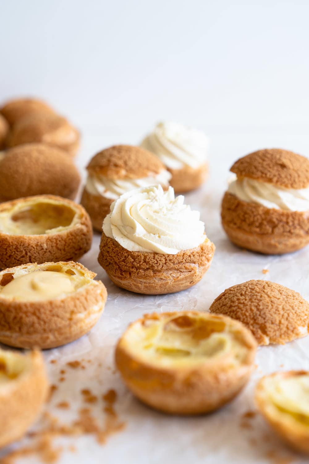 Choux au Craquelin - Cream Puffs with Passionfruit Cream and Passionfruit Whipped Cream. Crispy, light cream puffs, topped with crunchy craquelin, are filled with a tart passionfruit cream, then topped with a smooth passionfruit whipped cream. The perfect dessert for if you are feeling a little fancy! #creampuffs #passionfruit