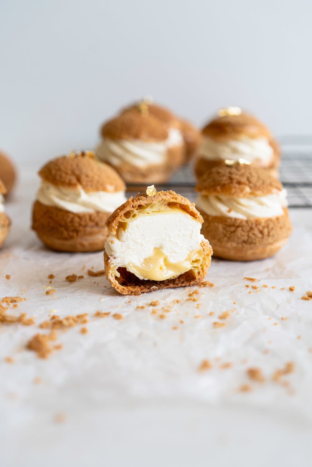 Choux au Craquelin - Cream Puffs with Passionfruit Cream and Passionfruit Whipped Cream. Crispy, light cream puffs, topped with crunchy craquelin, are filled with a tart passionfruit cream, then topped with a smooth passionfruit whipped cream. The perfect dessert for if you are feeling a little fancy! #creampuffs #passionfruit