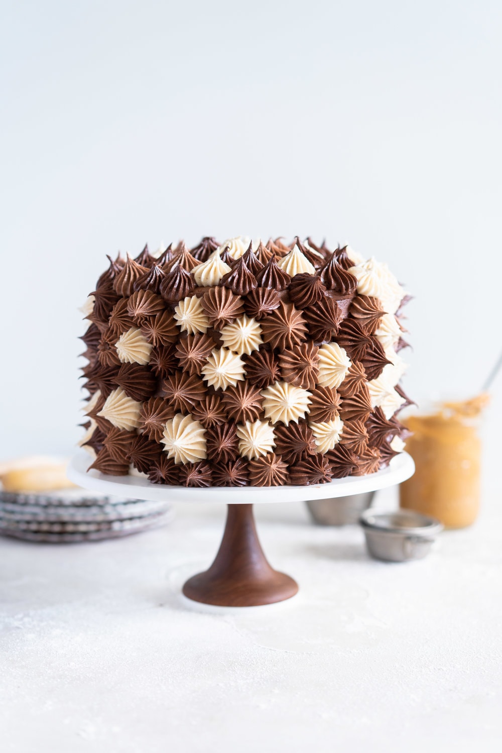 Chocolate and Peanut Butter Layer Cake with Chocolate and Peanut Butter Buttercream - this party cake is from the latest book from Bake from Scratch Magazine. Soft chocolate and peanut butter cake layers are sandwiched with chocolate and peanut butter buttercream, then finished off with playful blobs of the buttercream to create the perfect chocolate ombre cake. This cake is easy to make and is great to serve a crowd - you can't go wrong with peanut butter and chocolate! #chocolatecake #peanutbuttercake #chocolatebuttercream #peanutbutterbuttercream