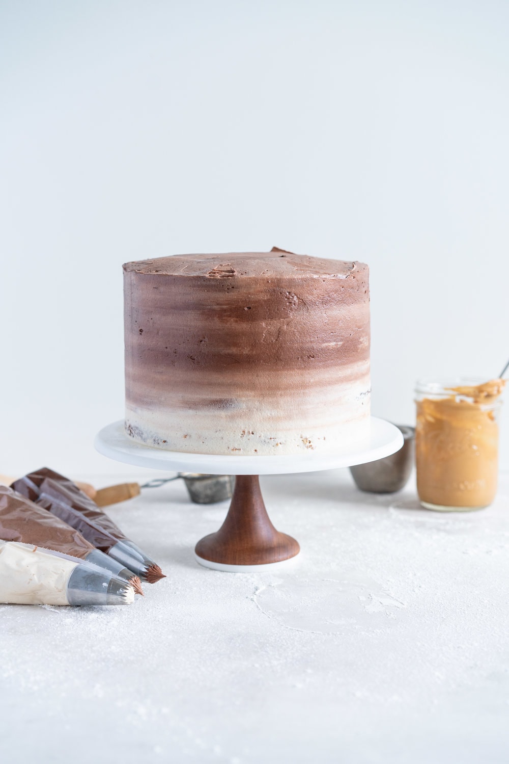 Chocolate and Peanut Butter Layer Cake with Chocolate and Peanut Butter Buttercream - this party cake is from the latest book from Bake from Scratch Magazine. Soft chocolate and peanut butter cake layers are sandwiched with chocolate and peanut butter buttercream, then finished off with playful blobs of the buttercream to create the perfect chocolate ombre cake. This cake is easy to make and is great to serve a crowd - you can't go wrong with peanut butter and chocolate! #chocolatecake #peanutbuttercake #chocolatebuttercream #peanutbutterbuttercream