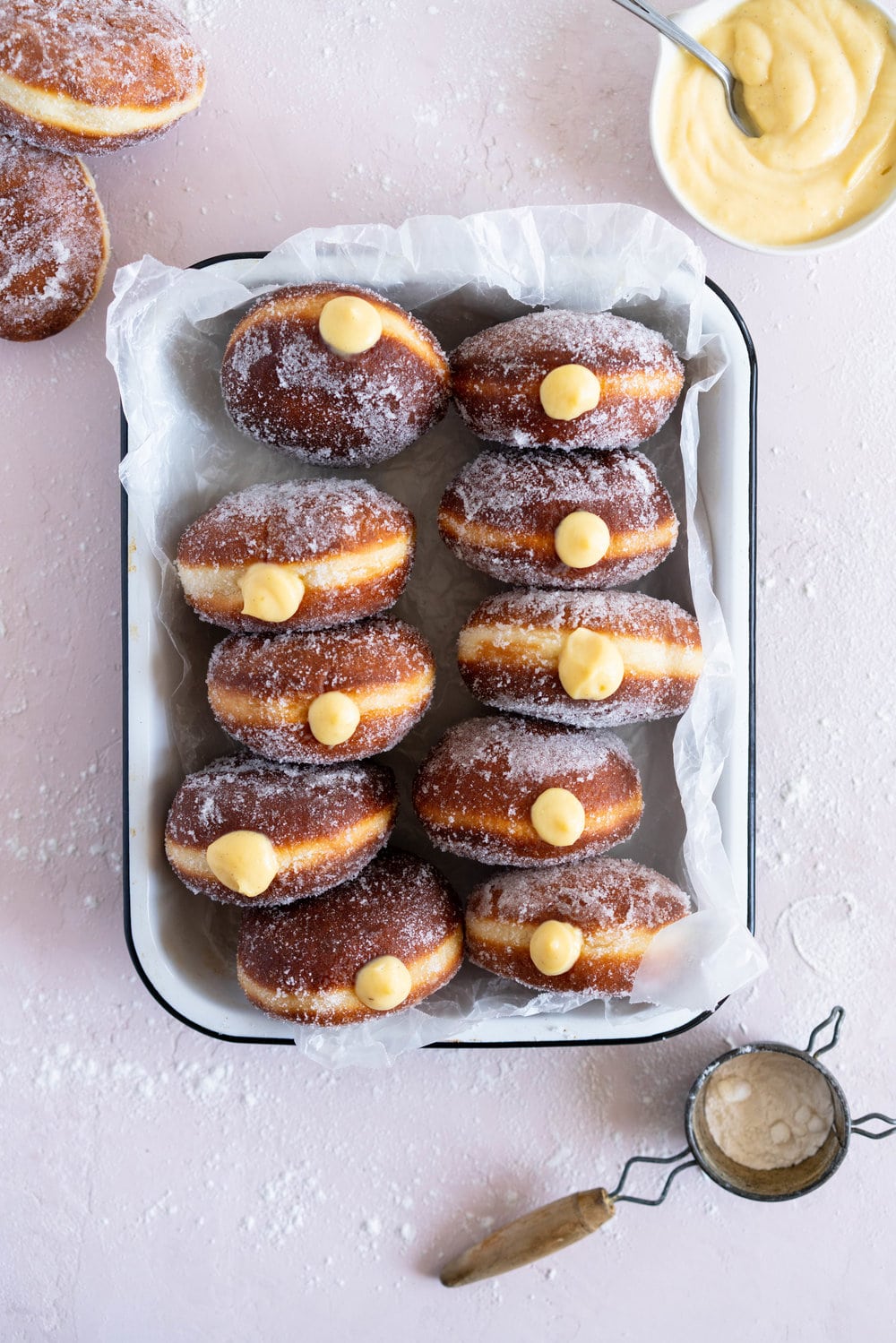 Malasadas with Liliko'i (Passionfruit) Pastry Cream Filling from Alana Kysar's new book, Aloha Kitchen. Malasadas are Portuguese style doughnuts, which are soft and fluffy. They are fried off, then rolled in sugar, then filled with a silky liliko'i pastry cream. These are the perfect indulgent treat, and are super easy to make. #malasadas #doughnuts #lilikoi #passionfruit