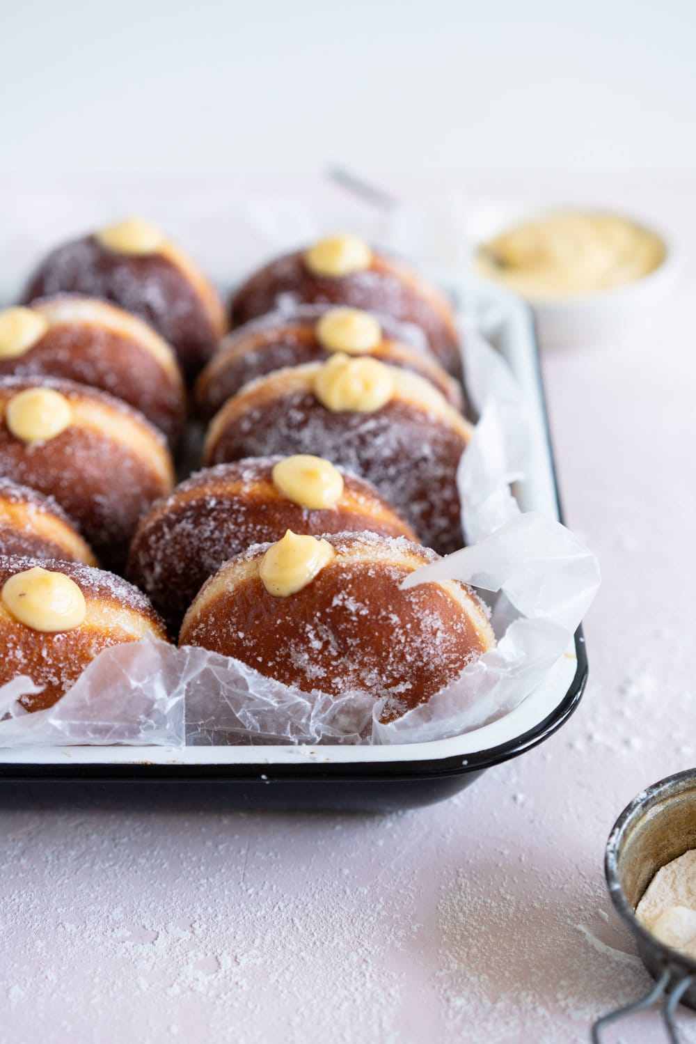 Malasadas with Liliko'i (Passionfruit) Pastry Cream Filling from Alana Kysar's new book, Aloha Kitchen. Malasadas are Portuguese style doughnuts, which are soft and fluffy. They are fried off, then rolled in sugar, then filled with a silky liliko'i pastry cream. These are the perfect indulgent treat, and are super easy to make. #malasadas #doughnuts #lilikoi #passionfruit