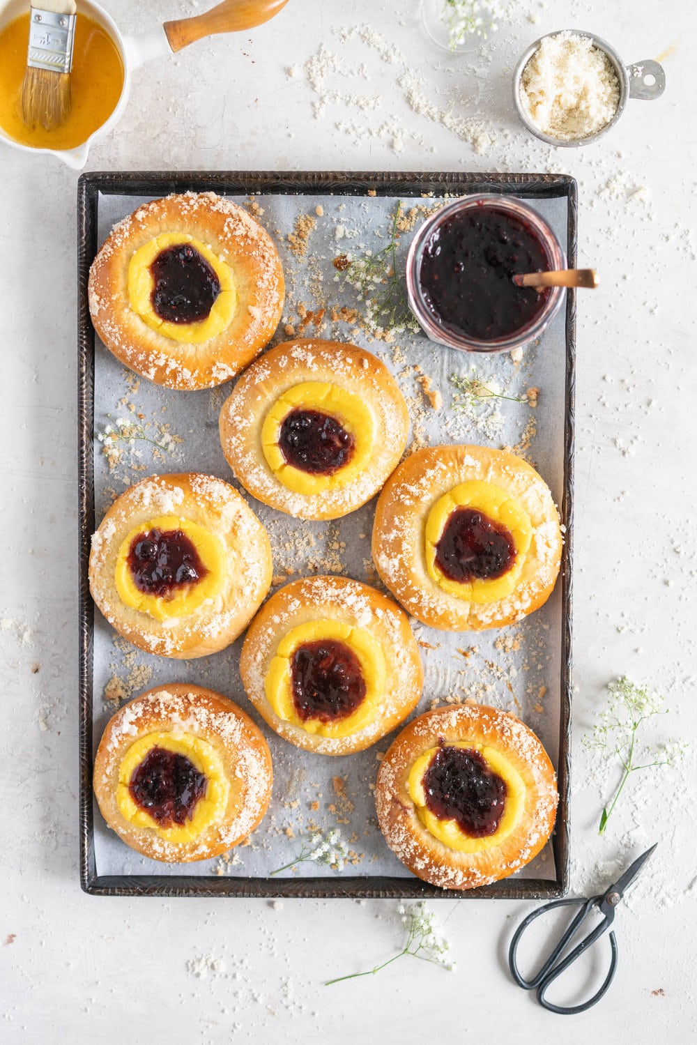 Custard Brioche Buns with Bonne Maman Mixed Berry Preserves and Vanilla bean Streusel. Light and fluffy brioche rounds are filled with a vanilla bean custard, then finished with a swirl of Bonne Maman Mixed berry preserves, and a sprinkle of vanilla bean streusel. These are perfect for a super easy but incredibly delicious brunch, as everything can be prepared the night before, making assembling the next morning super easy. #brioche #custardbun #breakfastpastry