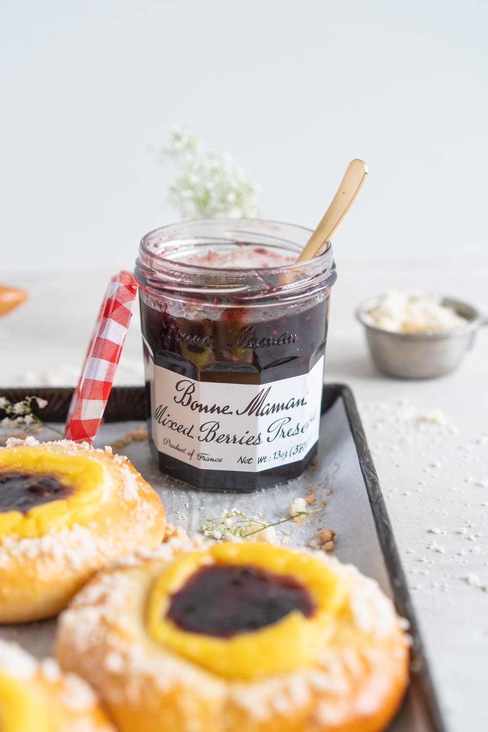 Custard Brioche Buns with Bonne Maman Mixed Berry Preserves and Vanilla bean Streusel. Light and fluffy brioche rounds are filled with a vanilla bean custard, then finished with a swirl of Bonne Maman Mixed berry preserves, and a sprinkle of vanilla bean streusel. These are perfect for a super easy but incredibly delicious brunch, as everything can be prepared the night before, making assembling the next morning super easy. #brioche #custardbun #breakfastpastry