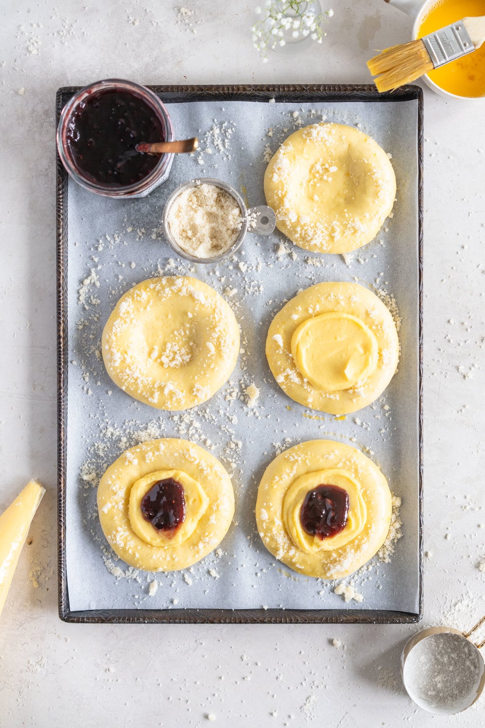 Custard Brioche Buns with Bonne Maman Mixed Berry Preserves and Vanilla bean Streusel. Light and fluffy brioche rounds are filled with a vanilla bean custard, then finished with a swirl of Bonne Maman Mixed berry preserves, and a sprinkle of vanilla bean streusel. These are perfect for a super easy but incredibly delicious brunch, as everything can be prepared the night before, making assembling the next morning super easy. #brioche #custardbun #breakfastpastry
