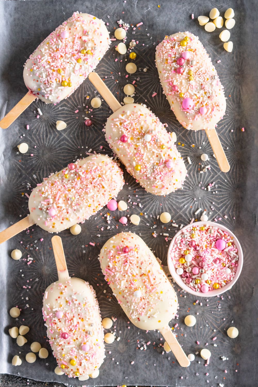 A simple stir together raspberry philadelphia style ice-cream base is churned then elevated with a raspberry ripple, before being frozen into ice cream pops and finished with a super easy white chocolate magic shell and loads of sprinkles. The perfect fancy treat for summer just around the corner - these last for a long time in the freezer so are great to have on hand when the ice cream craving strikes! #icecreampop #raspberryicecream #raspberrywhitechocolate
