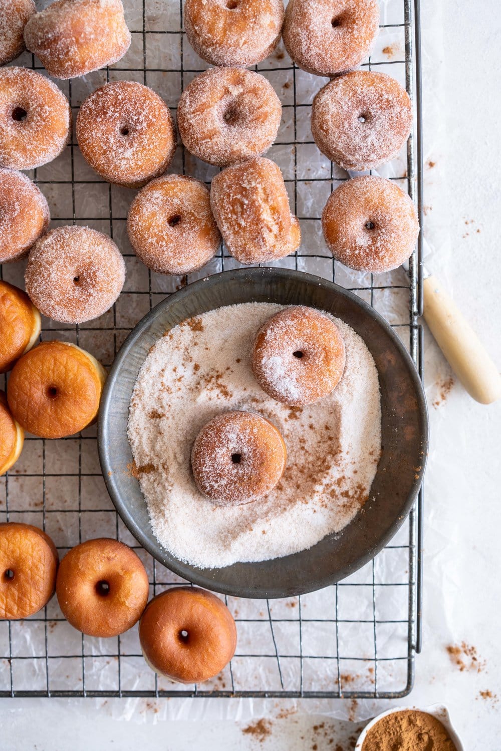 Fluffy miniature brioche doughnuts - an easy brioche dough is given an overnight rise, then rolled out and cut into tiny, perfect doughnuts, which are fried until golden brown, then rolled in cinnamon sugar. The perfect mouthful of fluffy doughnut, and sweet, spicy sugar. #briochedoughnut #cinnamonsugar #yeastdoughnut