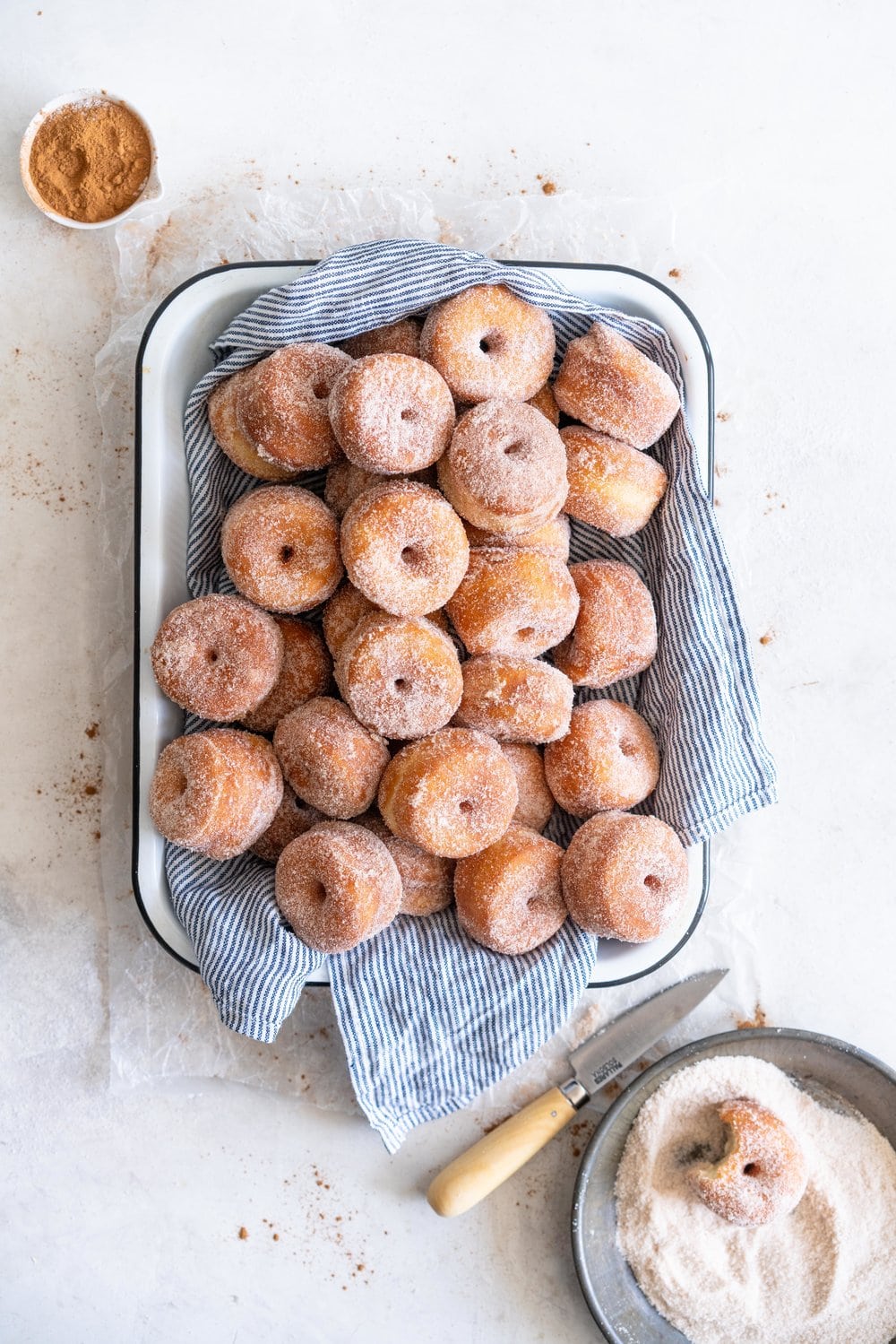 Fluffy miniature brioche doughnuts - an easy brioche dough is given an overnight rise, then rolled out and cut into tiny, perfect doughnuts, which are fried until golden brown, then rolled in cinnamon sugar. The perfect mouthful of fluffy doughnut, and sweet, spicy sugar. #briochedoughnut #cinnamonsugar #yeastdoughnut