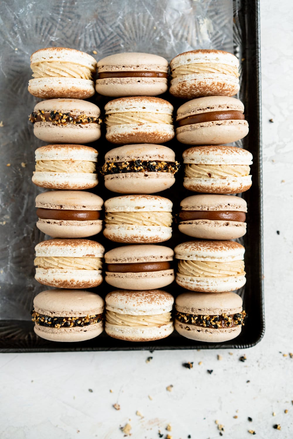 Sesame Macarons Two Ways - Chocolate Macarons with Salted Caramel Tahini Milk Chocolate Ganache and Sesame Brittle, and Vanilla Bean Macarons with Coffee German Buttercream and Halva. These two 'variations on a theme' show off the amazing versatility of tahini - a silky tahini chocolate ganache, and a halva stuffed macaron. #frenchmacarons #glutenfree #macarons