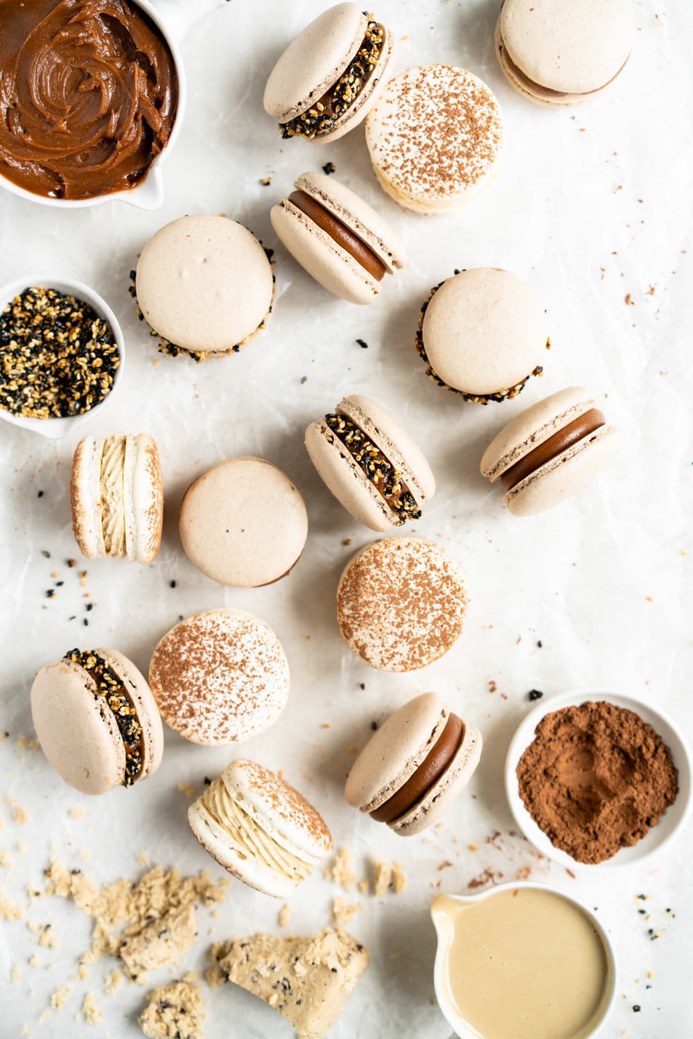 Sesame Macarons Two Ways - Chocolate Macarons with Salted Caramel Tahini Milk Chocolate Ganache and Sesame Brittle, and Vanilla Bean Macarons with Coffee German Buttercream and Halva. These two 'variations on a theme' show off the amazing versatility of tahini - a silky tahini chocolate ganache, and a halva stuffed macaron. #frenchmacarons #glutenfree #macarons