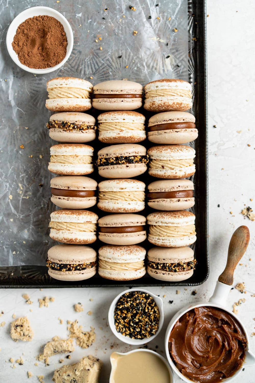 Sesame Macarons Two Ways - Chocolate Macarons with Salted Caramel Tahini Milk Chocolate Ganache and Sesame Brittle, and Vanilla Bean Macarons with Coffee German Buttercream and Halva. These two 'variations on a theme' show off the amazing versatility of tahini - a silky tahini chocolate ganache, and a halva stuffed macaron. #frenchmacarons #glutenfree #macarons