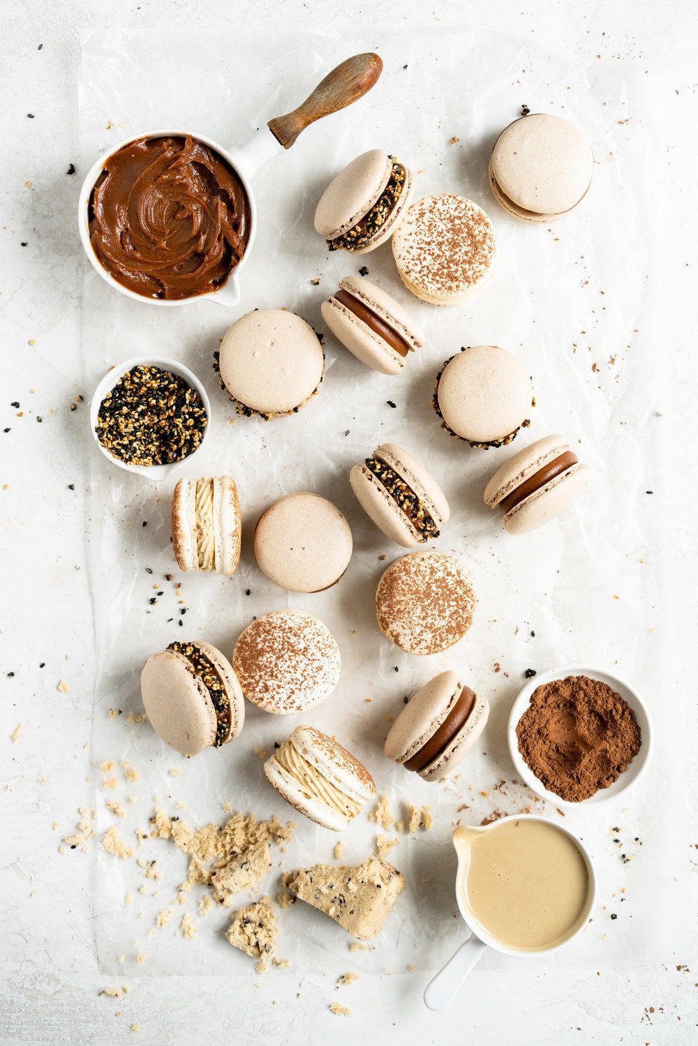 Sesame Macarons Two Ways - Chocolate Macarons with Salted Caramel Tahini Milk Chocolate Ganache and Sesame Brittle, and Vanilla Bean Macarons with Coffee German Buttercream and Halva. These two 'variations on a theme' show off the amazing versatility of tahini - a silky tahini chocolate ganache, and a halva stuffed macaron. #frenchmacarons #glutenfree #macarons