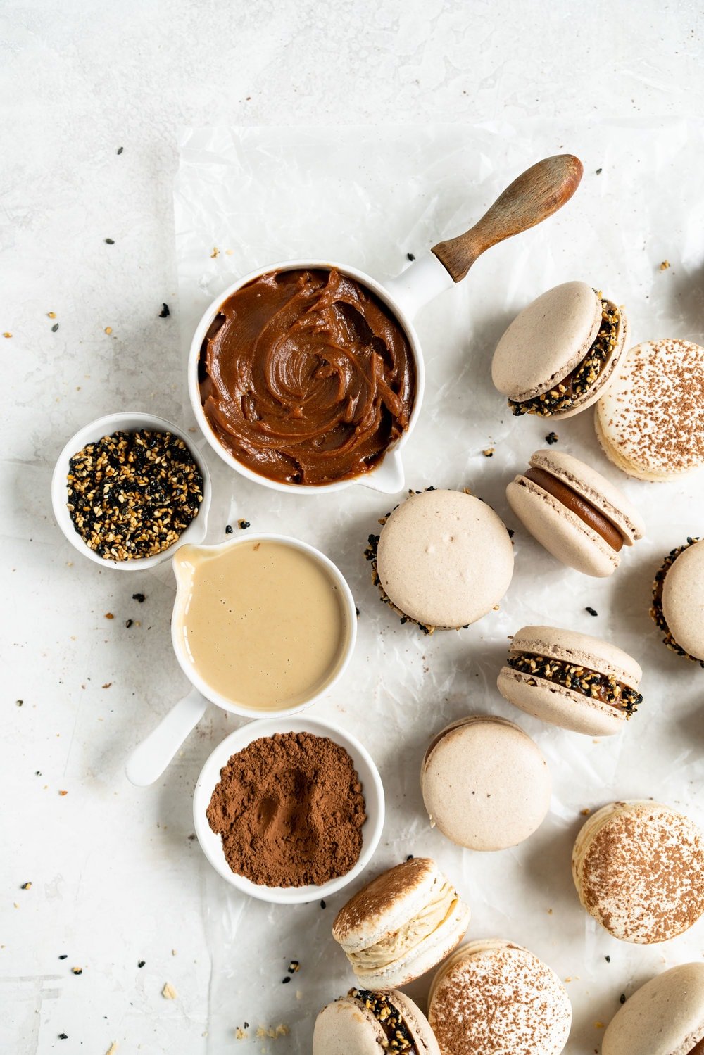 Sesame Macarons Two Ways - Chocolate Macarons with Salted Caramel Tahini Milk Chocolate Ganache and Sesame Brittle, and Vanilla Bean Macarons with Coffee German Buttercream and Halva. These two 'variations on a theme' show off the amazing versatility of tahini - a silky tahini chocolate ganache, and a halva stuffed macaron. #frenchmacarons #glutenfree #macarons