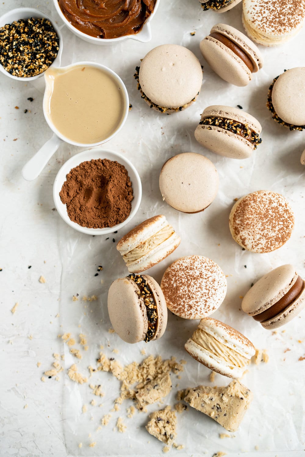 Sesame Macarons Two Ways - Chocolate Macarons with Salted Caramel Tahini Milk Chocolate Ganache and Sesame Brittle, and Vanilla Bean Macarons with Coffee German Buttercream and Halva. These two 'variations on a theme' show off the amazing versatility of tahini - a silky tahini chocolate ganache, and a halva stuffed macaron. #frenchmacarons #glutenfree #macarons