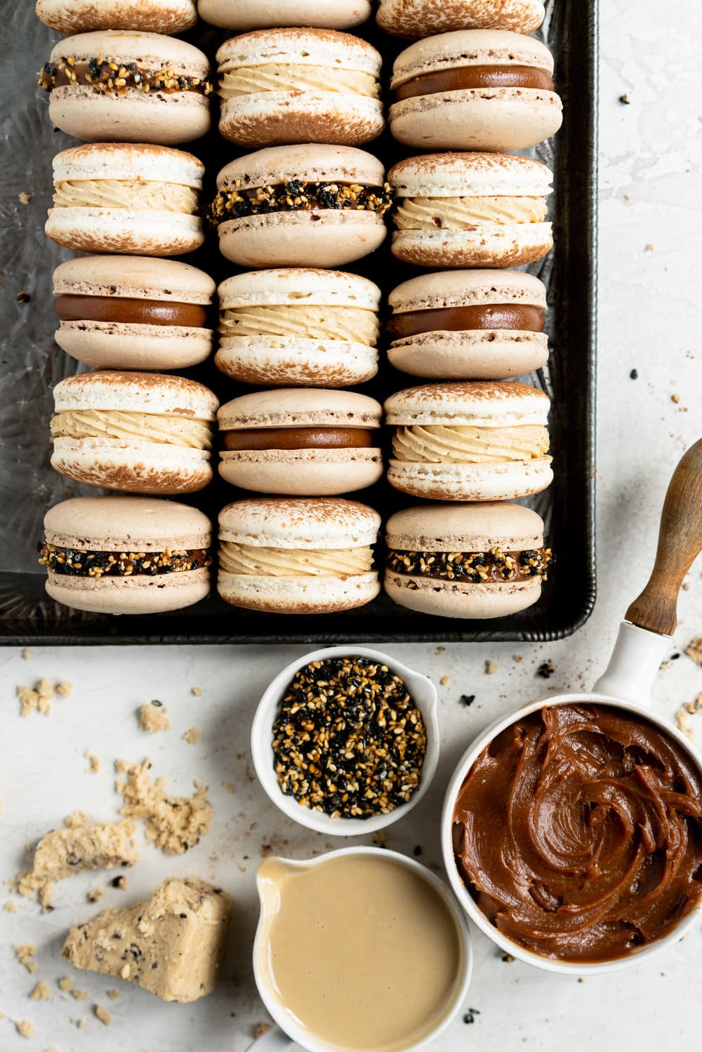 Sesame Macarons Two Ways - Chocolate Macarons with Salted Caramel Tahini Milk Chocolate Ganache and Sesame Brittle, and Vanilla Bean Macarons with Coffee German Buttercream and Halva. These two 'variations on a theme' show off the amazing versatility of tahini - a silky tahini chocolate ganache, and a halva stuffed macaron. #frenchmacarons #glutenfree #macarons