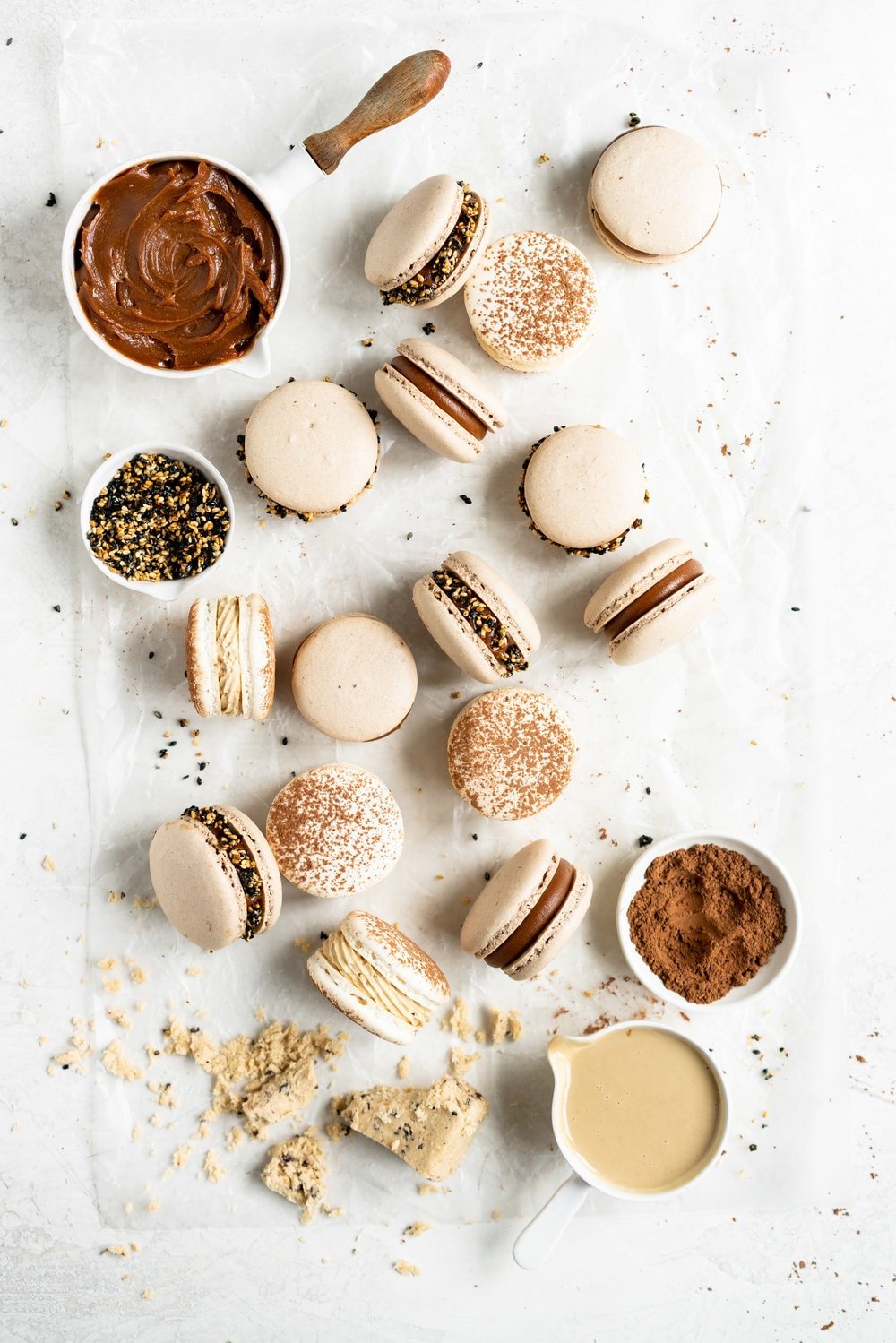 Sesame Macarons Two Ways - Chocolate Macarons with Salted Caramel Tahini Milk Chocolate Ganache and Sesame Brittle, and Vanilla Bean Macarons with Coffee German Buttercream and Halva. These two 'variations on a theme' show off the amazing versatility of tahini - a silky tahini chocolate ganache, and a halva stuffed macaron. #frenchmacarons #glutenfree #macarons