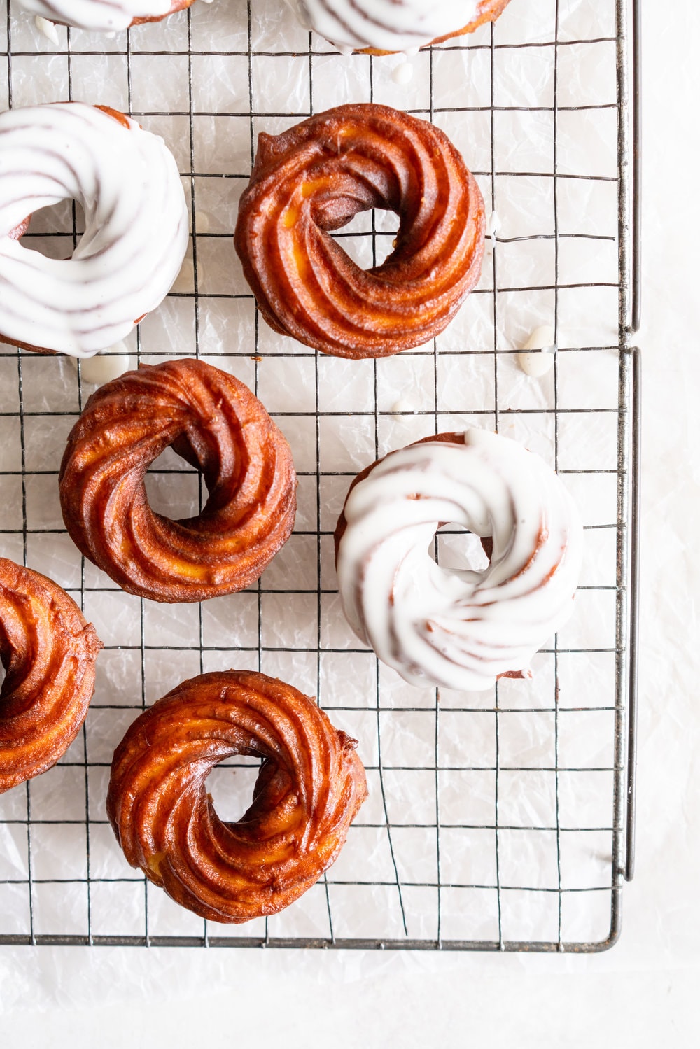 Lemon Crullers with Lemon and Honey Glaze - Fluffy, crispy lemon scented crullers are dipped in a lemon and honey glaze and finished with delicate gold leaf. Crullers are made by frying choux dough, and are a must-try if you haven't made them before! #crullers #doughnut #lemoncruller
