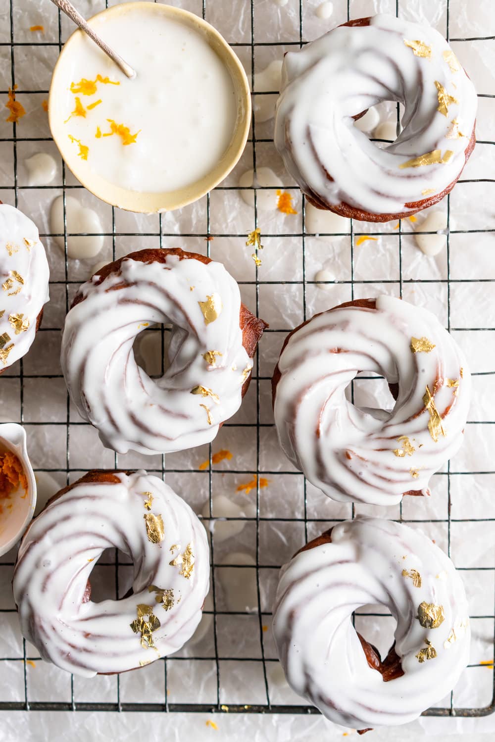 Lemon Crullers with Lemon and Honey Glaze - Fluffy, crispy lemon scented crullers are dipped in a lemon and honey glaze and finished with delicate gold leaf. Crullers are made by frying choux dough, and are a must-try if you haven't made them before! #crullers #doughnut #lemoncruller