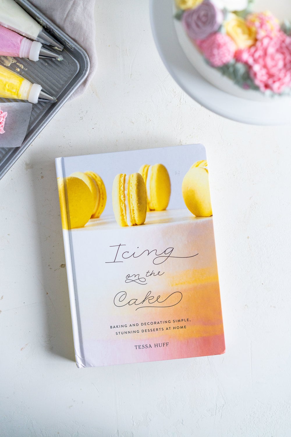 Lavender Blackberry Cake with Cream Cheese Frosting and a Piped Floral Wreath. Layers of delicately flavoured lavender cake are filled with a cream cheese frosting and blackberry jam, and topped with a beautiful floral wreath made from piped swiss meringue buttercream flowers. #pipedflowers #lavendercake #swissmeringuebuttercream #icingonthecakebook