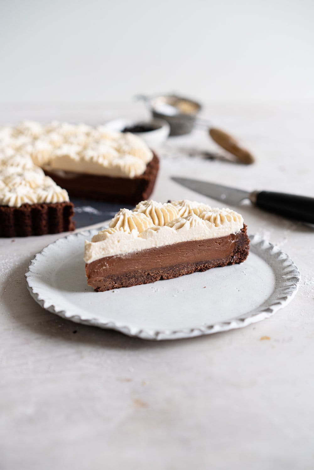Dark Chocolate Salted Caramel Ganache Tart with Chocolate Graham Cracker Crust and Earl Grey Mascarpone Whipped Cream - this chocolate tart comes together quickly, and is the perfect easy dessert that easily feeds a crowd. A crunch base is topped with a silky smooth chocolate salted caramel filling, and finished with an earl grey mascarpone whipped cream. #chocolatetart #saltedcaramel #earlgreywhippedcream