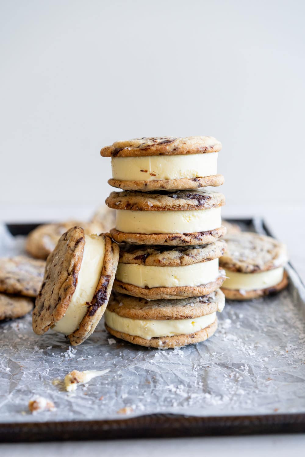 Chocolate Chip Cookie Ice Cream Sandwiches with Olive Oil Ice Cream. Thin and crispy chocolate chip cookies sandwich a creamy, smooth disc of olive oil ice cream. The perfect summer treat. #oliveoilicecream #icecreamsandwich #chocolatechipcookie