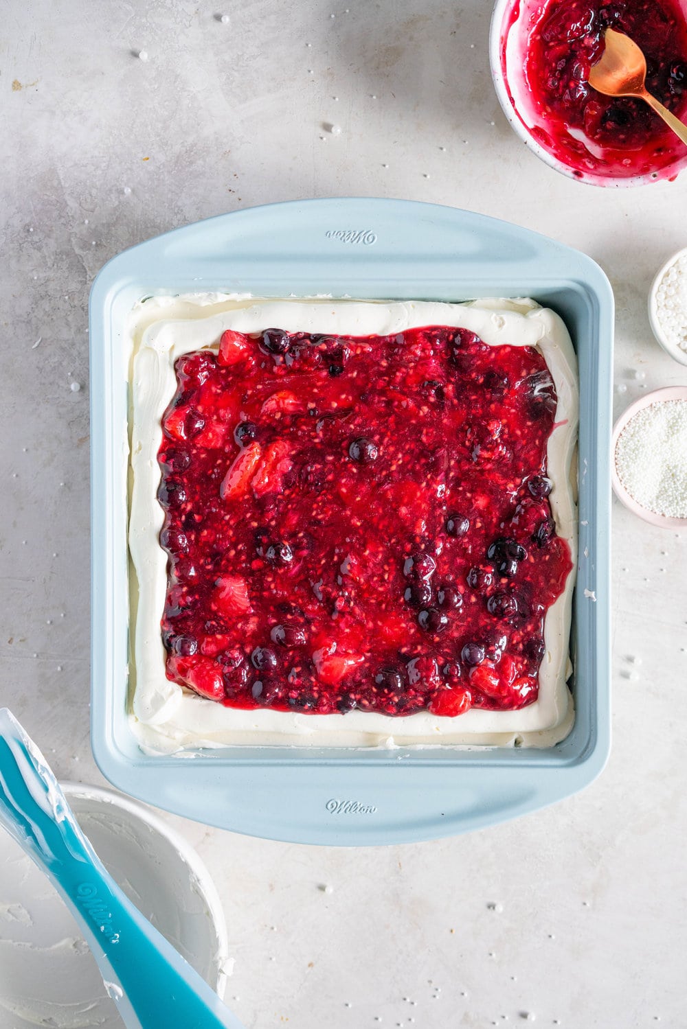 A super easy but delicious rich one bowl chocolate sheet cake is filled with a simple mixed berry cake filling and finished with a piped top using vanilla bean swiss meringue buttercream. This cake is baked in the new Wilton Texturra performance non-stick bakeware, and is finished with simple but beautiful piping in different shades of pink using various piping tips. This cake is simple yet elegant and is a perfect easy alternative to a layer cake. #chocolatecake #wilton #onebowlchocolatecake