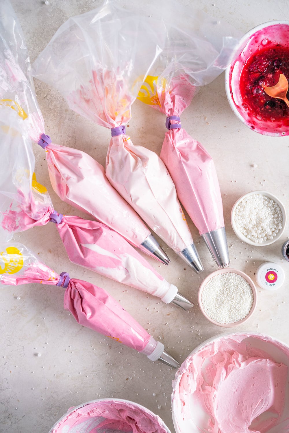 A super easy but delicious rich one bowl chocolate sheet cake is filled with a simple mixed berry cake filling and finished with a piped top using vanilla bean swiss meringue buttercream. This cake is baked in the new Wilton Texturra performance non-stick bakeware, and is finished with simple but beautiful piping in different shades of pink using various piping tips. This cake is simple yet elegant and is a perfect easy alternative to a layer cake. #chocolatecake #wilton #onebowlchocolatecake