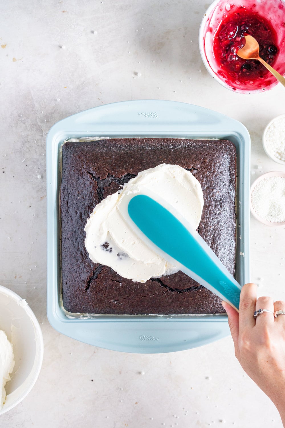 A super easy but delicious rich one bowl chocolate sheet cake is filled with a simple mixed berry cake filling and finished with a piped top using vanilla bean swiss meringue buttercream. This cake is baked in the new Wilton Texturra performance non-stick bakeware, and is finished with simple but beautiful piping in different shades of pink using various piping tips. This cake is simple yet elegant and is a perfect easy alternative to a layer cake. #chocolatecake #wilton #onebowlchocolatecake
