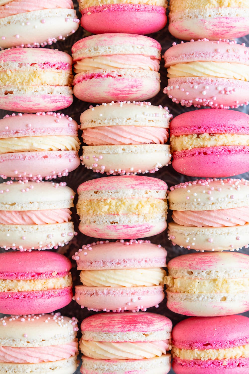 Strawberry shortcake macarons - French Macaron shells are filled with a strawberry filling, cream cheese german buttercream, and finished with a brown butter pie crumb crunch. These encompass summer in every bite. #strawberryshortcake #piecrumb #strawberrymacaron