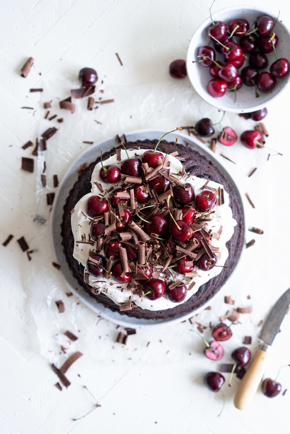 Black forest bundt cake - a rich, tender, chocolate cherry bundt cake that is studded with cherries is topped with fresh softly whipped cream, fresh cherries, and chocolate curls #blackforest #chocolatecherrybundt #chocolatebundtcake
