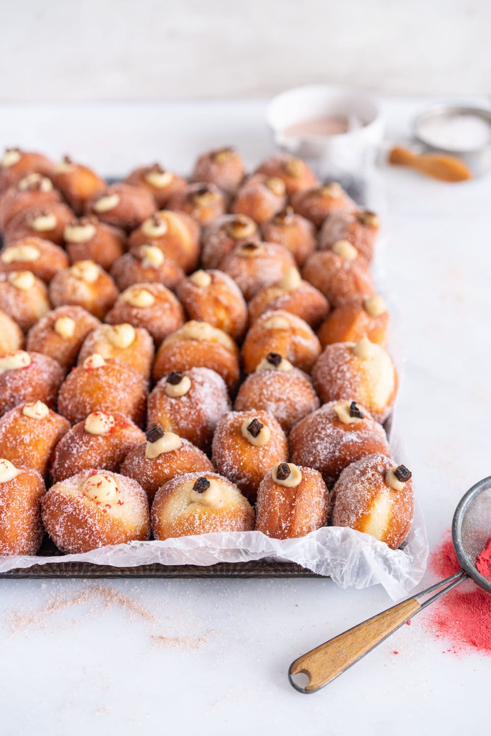 Perfectly fluffy mini brioche doughnuts are fried to perfection, rolled in sugar, and filled with flavoured pastry cream. A whole tray of mini doughnuts would be perfect for a special occasion or gathering, as they are a hit with all ages! #doughnut #briochedoughnut