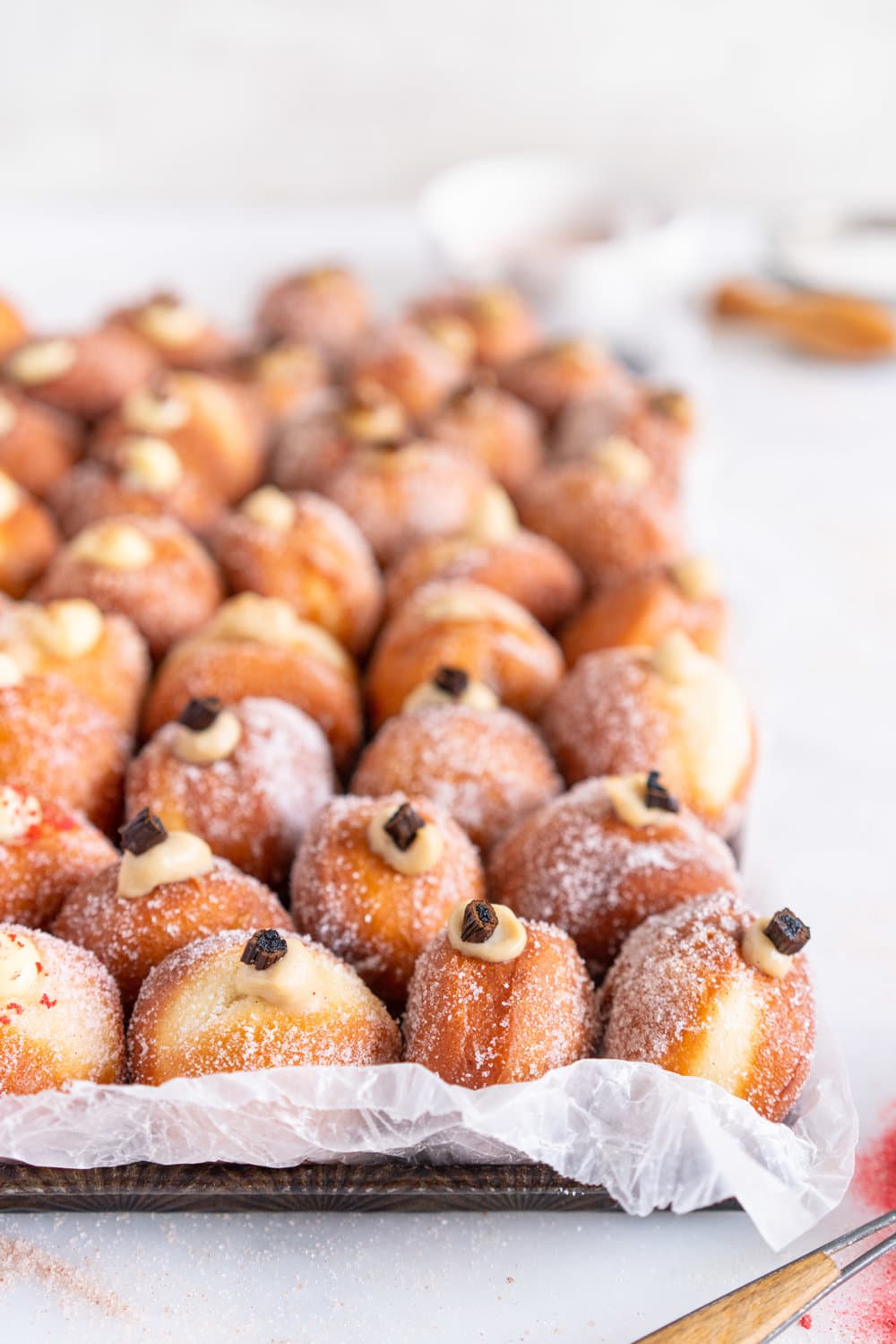 Perfectly fluffy mini brioche doughnuts are fried to perfection, rolled in sugar, and filled with flavoured pastry cream. A whole tray of mini doughnuts would be perfect for a special occasion or gathering, as they are a hit with all ages! #doughnut #briochedoughnut