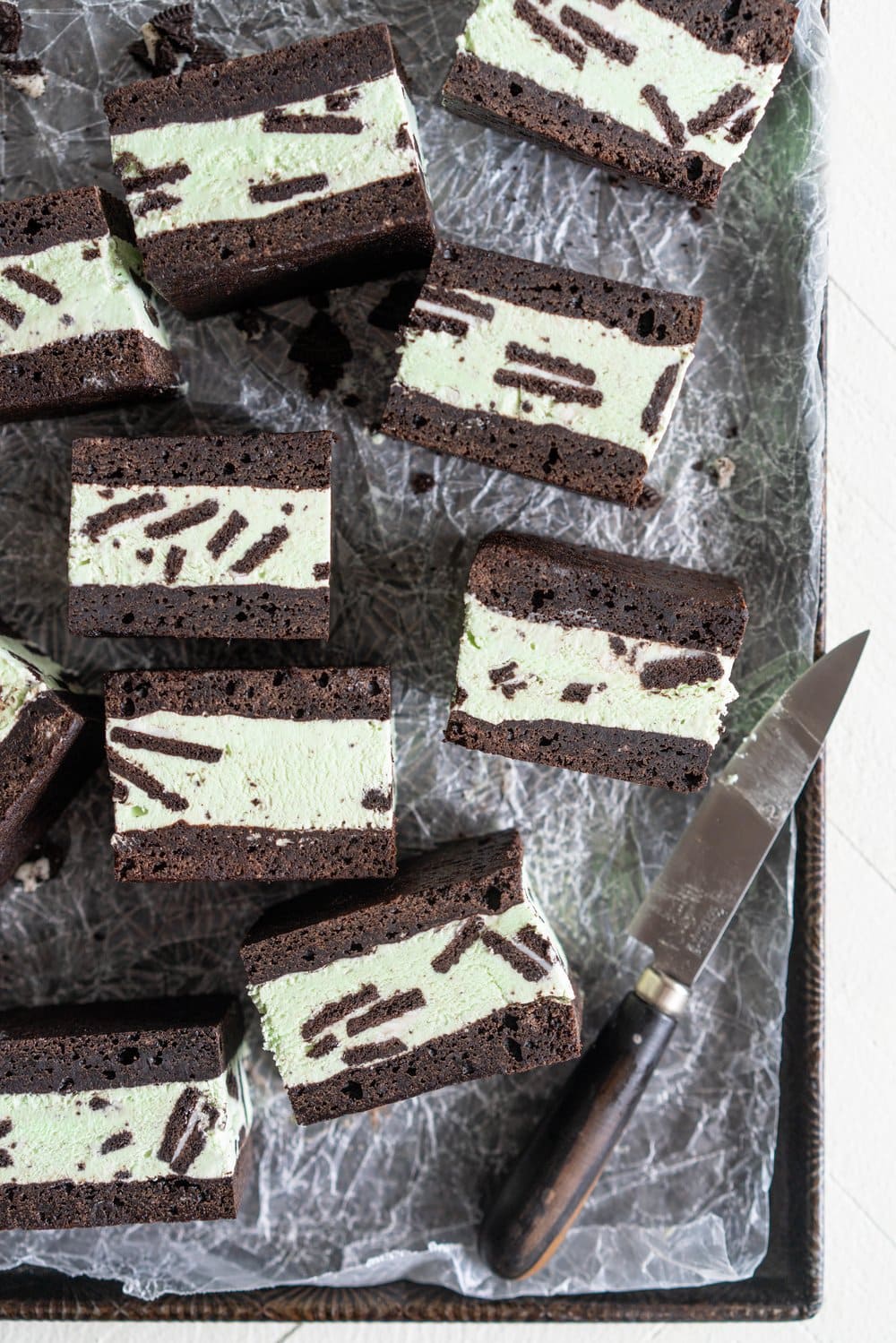 Black cocoa brownie ice cream sandwiches - black cocoa brownies are baked thin and fudgy, then layered up with smooth oreo mint philadelphia style ice cream. These are the perfect summer treat and great for feeding a crowd, you can't go wrong with a good brownie ice cream sandwich. #brownie #icecreamsandwich #mintchip #philadelphiaicecream