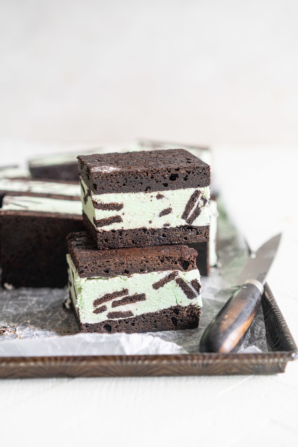 Black cocoa brownie ice cream sandwiches - black cocoa brownies are baked thin and fudgy, then layered up with smooth oreo mint philadelphia style ice cream. These are the perfect summer treat and great for feeding a crowd, you can't go wrong with a good brownie ice cream sandwich. #brownie #icecreamsandwich #mintchip #philadelphiaicecream