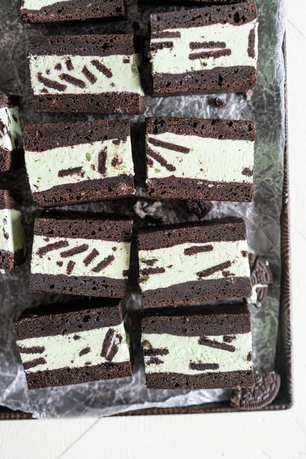 Black cocoa brownie ice cream sandwiches - black cocoa brownies are baked thin and fudgy, then layered up with smooth oreo mint philadelphia style ice cream. These are the perfect summer treat and great for feeding a crowd, you can't go wrong with a good brownie ice cream sandwich. #brownie #icecreamsandwich #mintchip #philadelphiaicecream