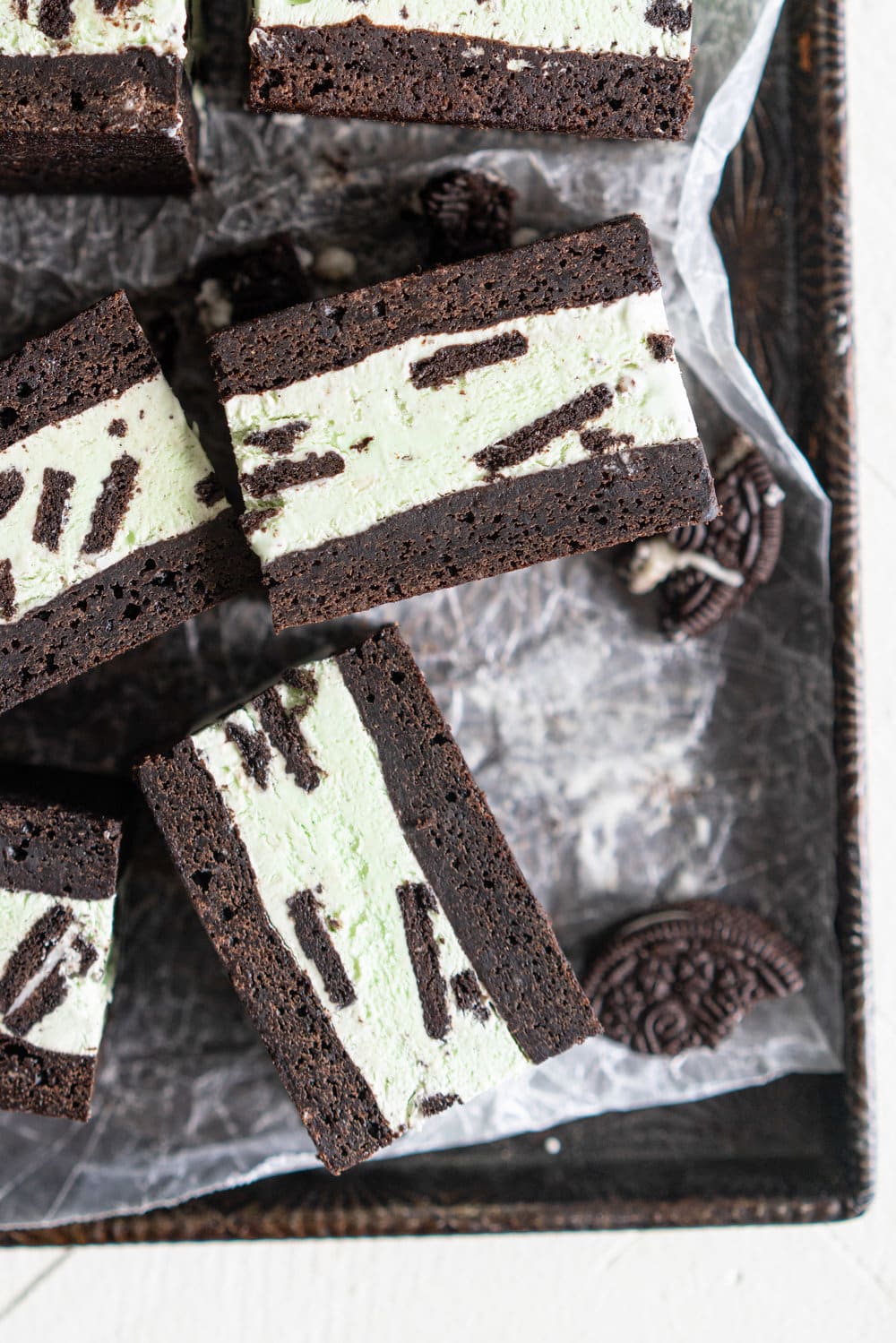 Black cocoa brownie ice cream sandwiches - black cocoa brownies are baked thin and fudgy, then layered up with smooth oreo mint philadelphia style ice cream. These are the perfect summer treat and great for feeding a crowd, you can't go wrong with a good brownie ice cream sandwich. #brownie #icecreamsandwich #mintchip #philadelphiaicecream