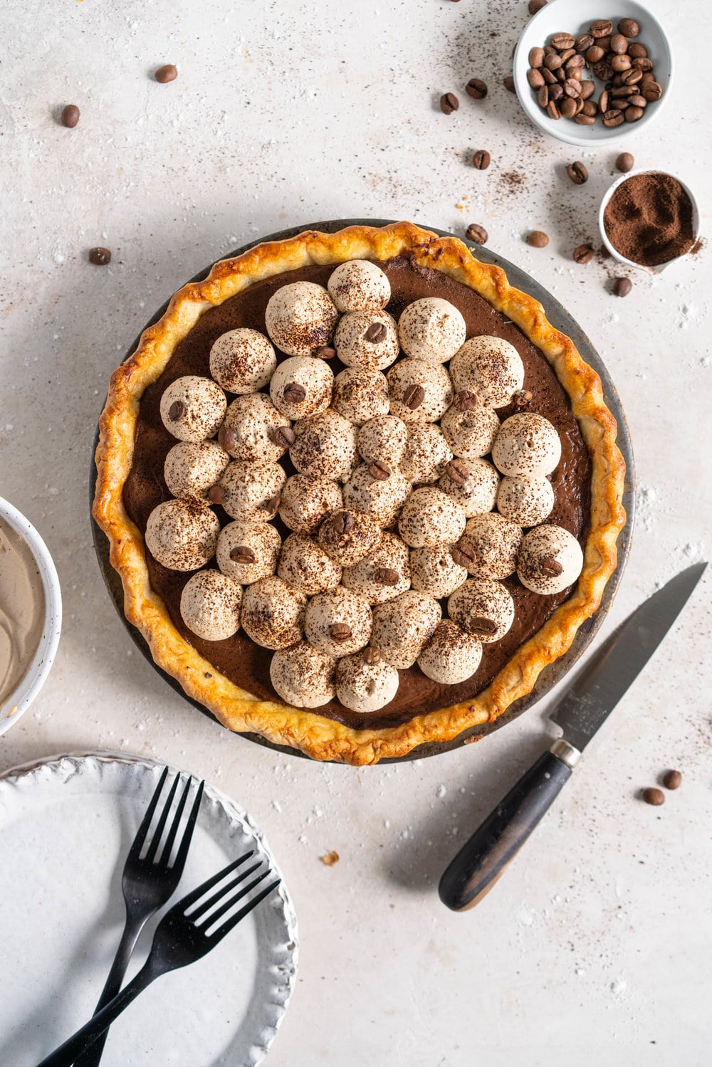 Mocha Cream pie with espresso whipped cream - a crispy blind baked pie crust is filled with a mocha pudding filling and topped with clouds of espresso flavoured whipped cream, before being finished off with coffee beans and espresso powder. This pie is super simple to make and is a coffee lover's dream. #mochapie #creampie #mocha #cloudykitchenpie