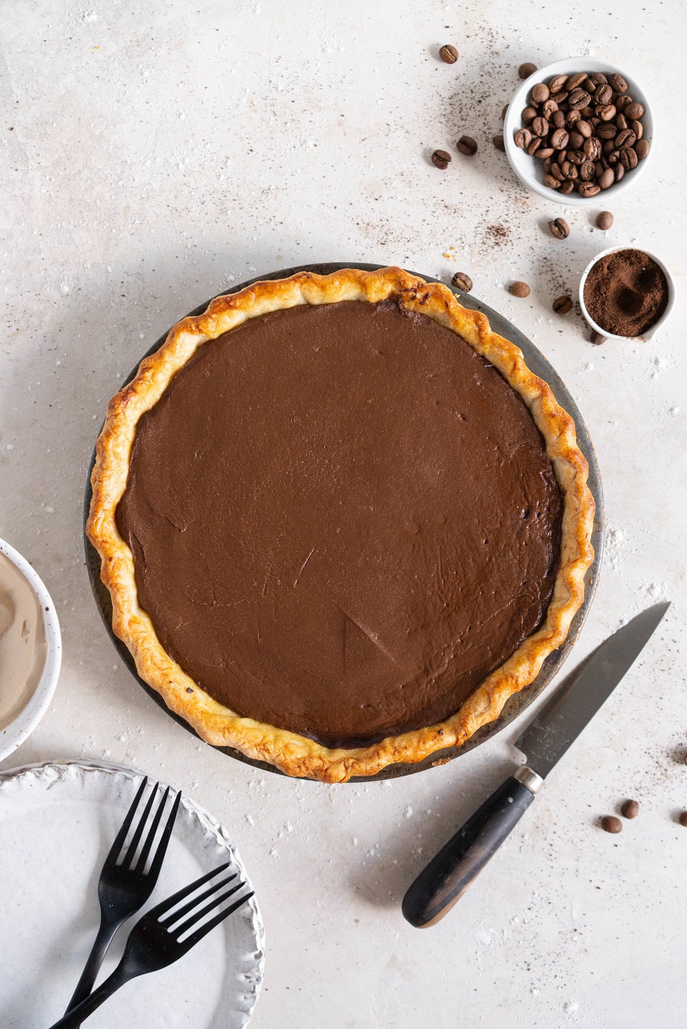 Mocha Cream pie with espresso whipped cream - a crispy blind baked pie crust is filled with a mocha pudding filling and topped with clouds of espresso flavoured whipped cream, before being finished off with coffee beans and espresso powder. This pie is super simple to make and is a coffee lover's dream. #mochapie #creampie #mocha #cloudykitchenpie