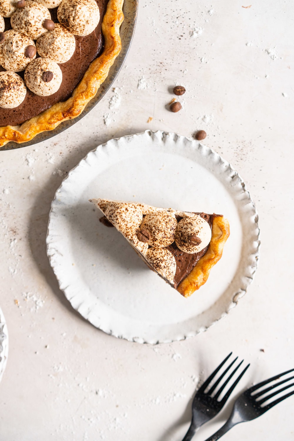 Mocha Cream pie with espresso whipped cream - a crispy blind baked pie crust is filled with a mocha pudding filling and topped with clouds of espresso flavoured whipped cream, before being finished off with coffee beans and espresso powder. This pie is super simple to make and is a coffee lover's dream. #mochapie #creampie #mocha #cloudykitchenpie