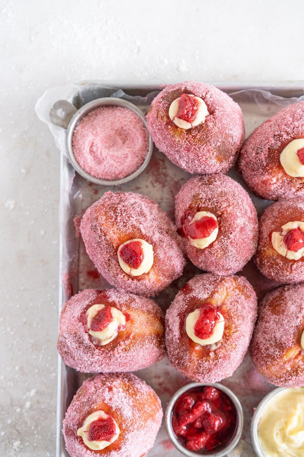 Brioche Doughnuts with Vanilla Bean Pastry Cream and Roasted Strawberry Filling. Roasting strawberries brings out the most amazing sweet flavour, which pairs so perfectly with the smooth vanilla bean pastry cream and fluffy brioche doughnut dough which is rolled in a freeze dried strawberry sugar. #briochedoughnut #strawberrydoughnut #roastedstrawberry