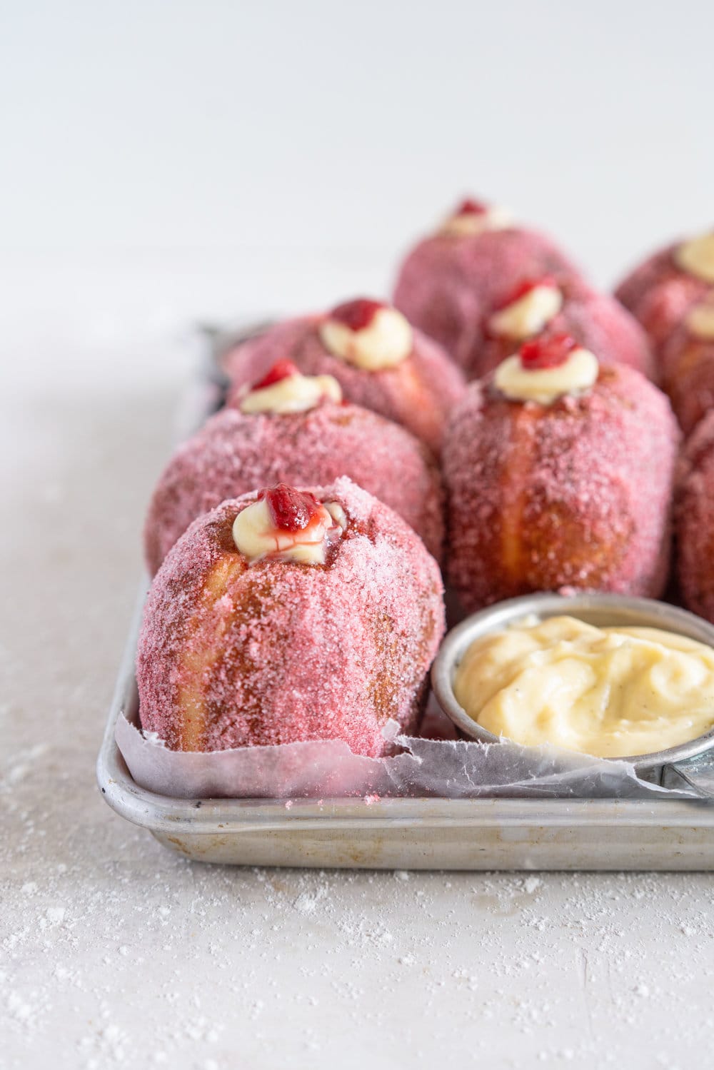 Brioche Doughnuts with Vanilla Bean Pastry Cream and Roasted Strawberry Filling. Roasting strawberries brings out the most amazing sweet flavour, which pairs so perfectly with the smooth vanilla bean pastry cream and fluffy brioche doughnut dough which is rolled in a freeze dried strawberry sugar. #briochedoughnut #strawberrydoughnut #roastedstrawberry