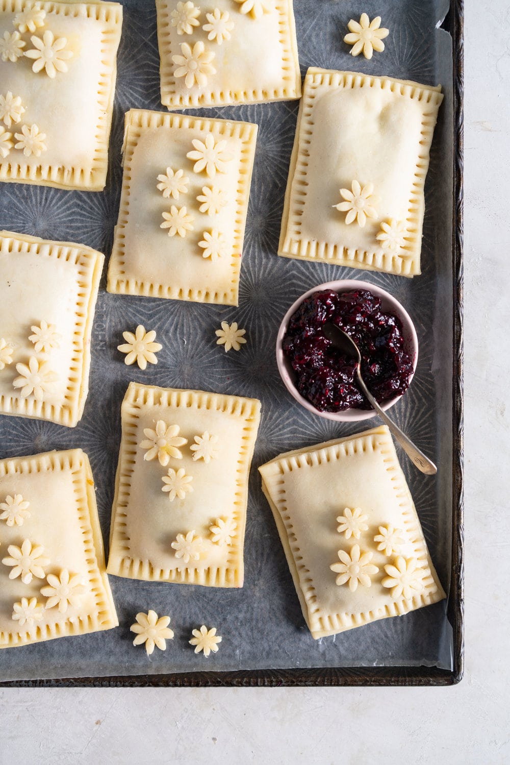 Mixed Berry and Cream Cheese Hand Pies - an easy flaky pie dough encases a mixed berry and vanilla bean cream cheese filling. These miniature pies are perfect for using up surplus cream cheese or jam that you may have, or for making use of slightly sad or tired berries. #handpies #easyhandpies #mixedberryjam