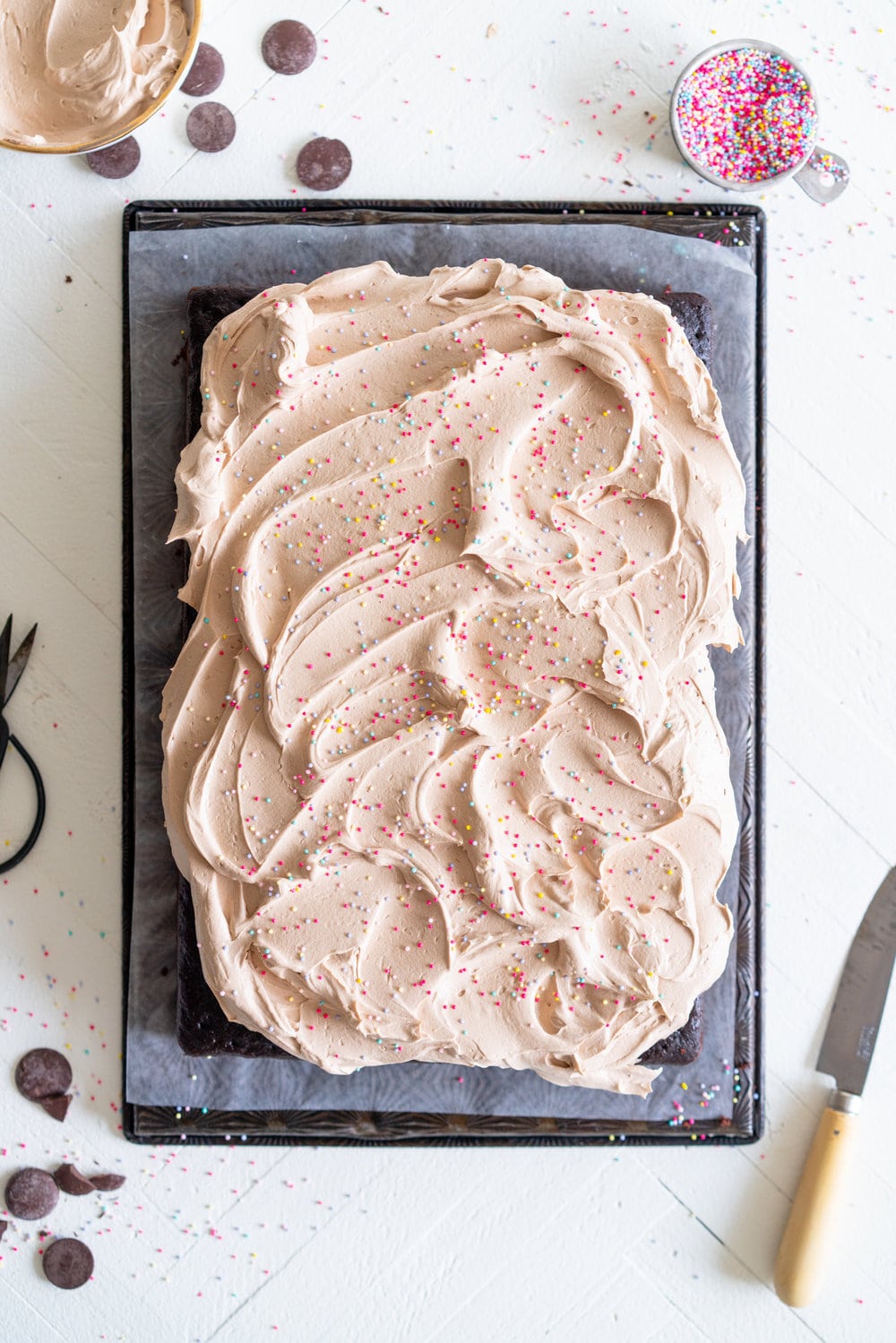 Chocolate sheet cake with milk chocolate german buttercream. This easy, from scratch chocolate sheet cake is enhanced with the flavour of olive oil, and bakes up nice and flat, making it the perfect sheet cake for decorating. It is topped with a silky, milk chocolate german buttercream. #sheetcake #germanbuttercream #chocolateoliveoilcake