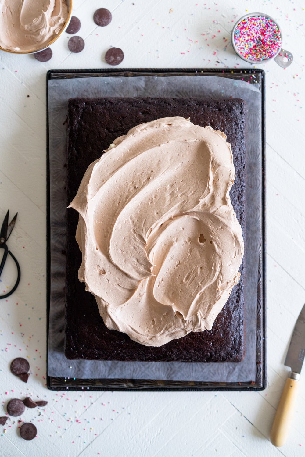Chocolate sheet cake with milk chocolate german buttercream. This easy, from scratch chocolate sheet cake is enhanced with the flavour of olive oil, and bakes up nice and flat, making it the perfect sheet cake for decorating. It is topped with a silky, milk chocolate german buttercream. #sheetcake #germanbuttercream #chocolateoliveoilcake