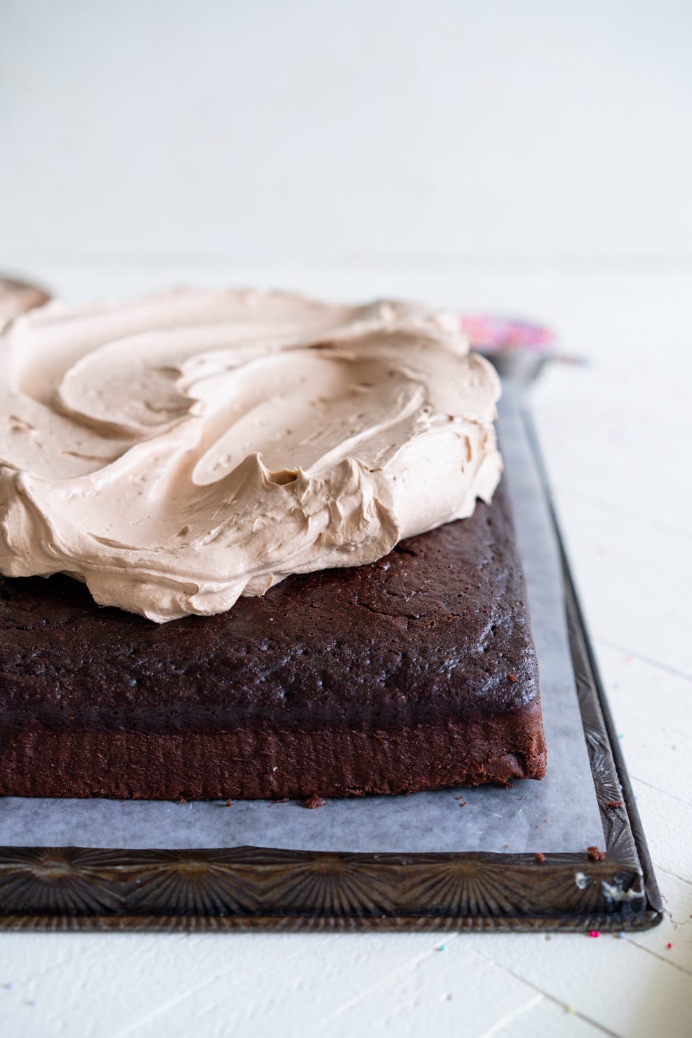 Chocolate sheet cake with milk chocolate german buttercream. This easy, from scratch chocolate sheet cake is enhanced with the flavour of olive oil, and bakes up nice and flat, making it the perfect sheet cake for decorating. It is topped with a silky, milk chocolate german buttercream. #sheetcake #germanbuttercream #chocolateoliveoilcake